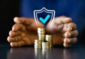 African American businessman counting coins to protect income and invest in long-term success. Professional finance manager securing his capital.